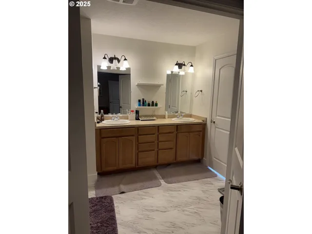 a bathroom with a double vanity sink and a mirror