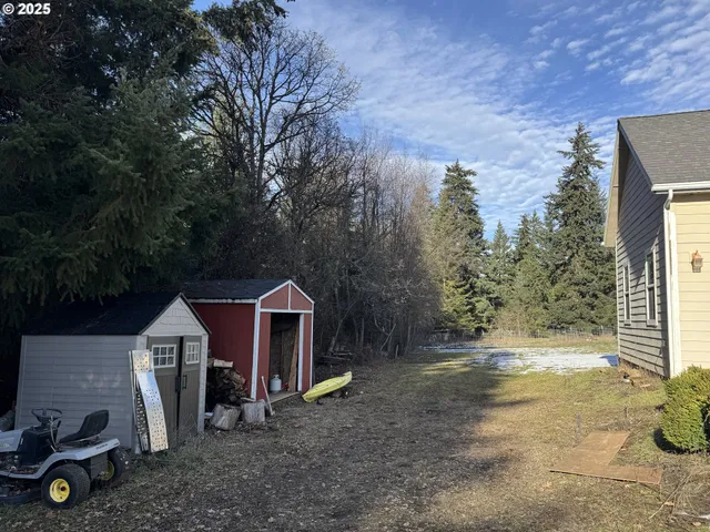 a view of a house with backyard and trees