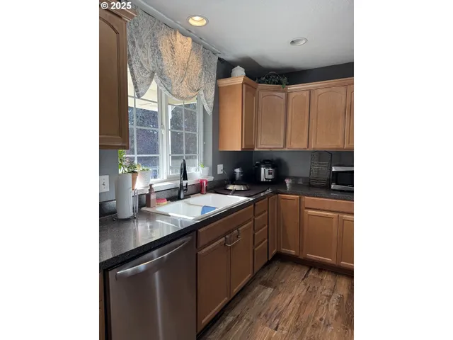 a kitchen with stainless steel appliances granite countertop a sink and cabinets