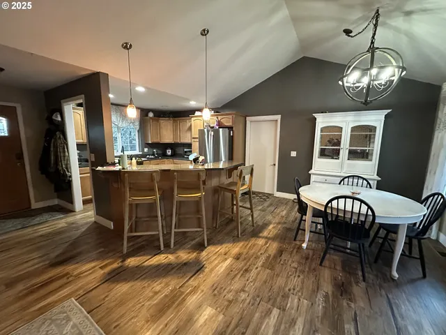 a view of a dining room with furniture a chandelier and wooden floor