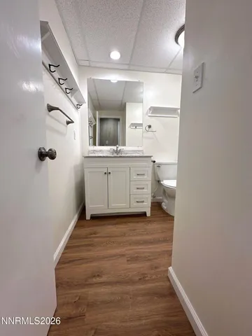 a bathroom with a granite countertop sink mirror vanity and toilet