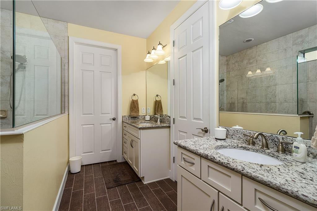 16309 Winfield Lane Naples, FL 34110 - Photo 24 of 35 a bathroom with a granite countertop sink and a mirror