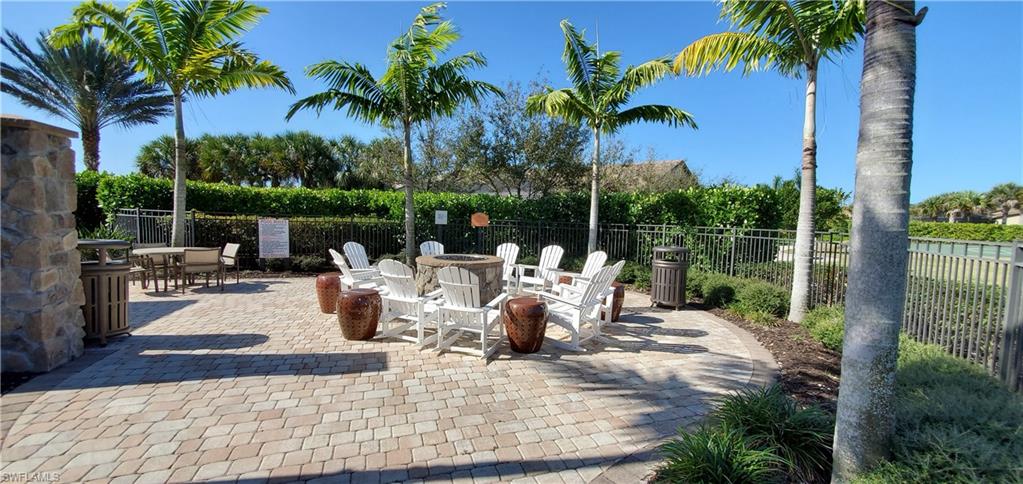 16309 Winfield Lane Naples, FL 34110 - Photo 34 of 35 a view of a patio with dining table and chairs potted plants and palm tree