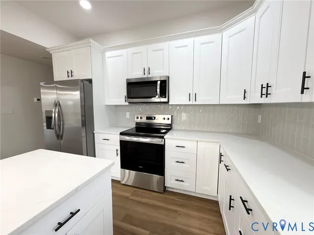 a kitchen with white cabinets and stainless steel appliances
