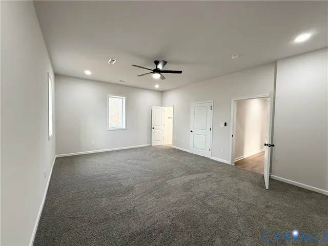 a view of an empty room with a ceiling fan