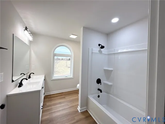 a bathroom with a bathtub shower sink and mirror