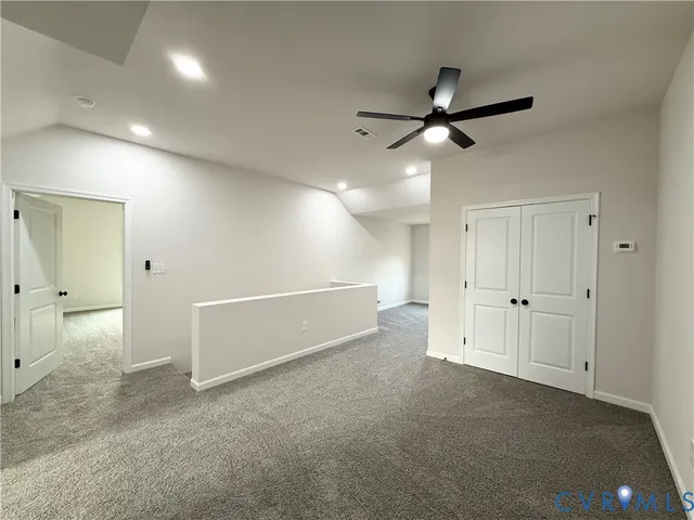 an empty room with closet and windows