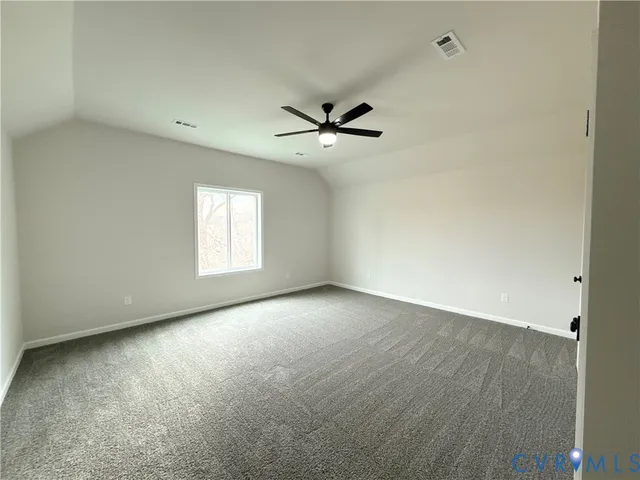 an empty room with a window and a ceiling fan
