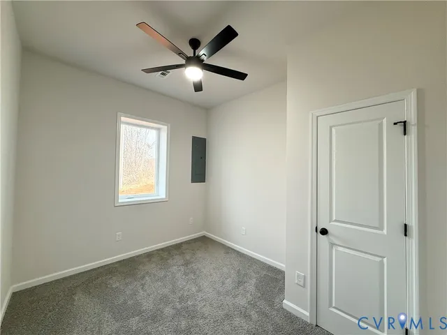 an empty room with windows and fan