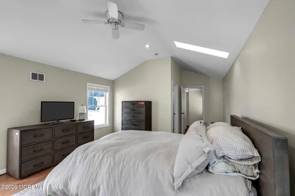 a bedroom with a bed and a flat tv screen on dresser