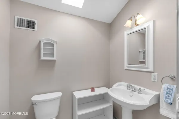 a bathroom with a toilet a sink and mirror
