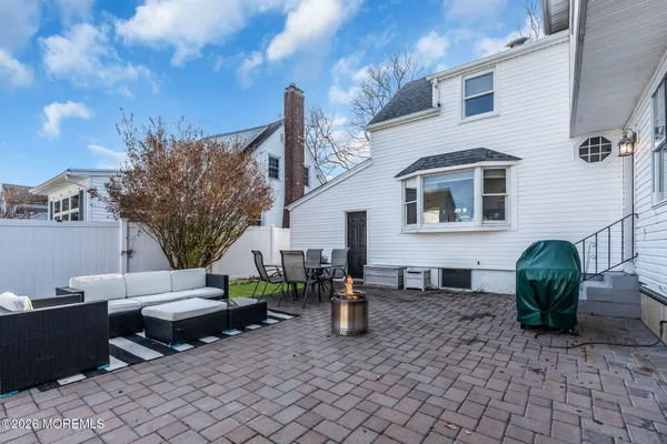 a backyard of a house with barbeque oven table and chairs