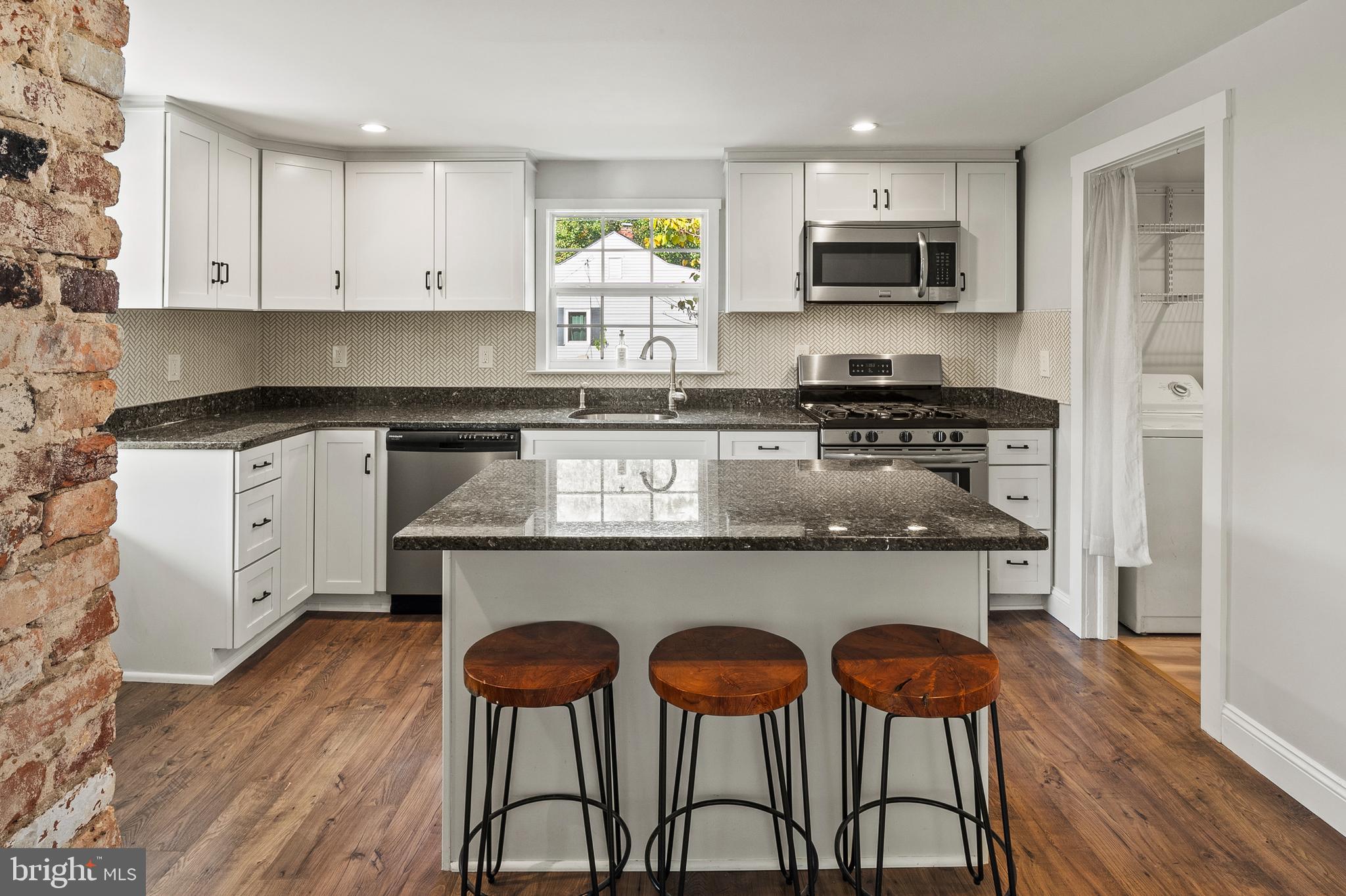 2201 Alvin Avenue Baltimore, MD 21228 - Photo 6 of 39 a kitchen with stainless steel appliances granite countertop a stove a sink and a white cabinets