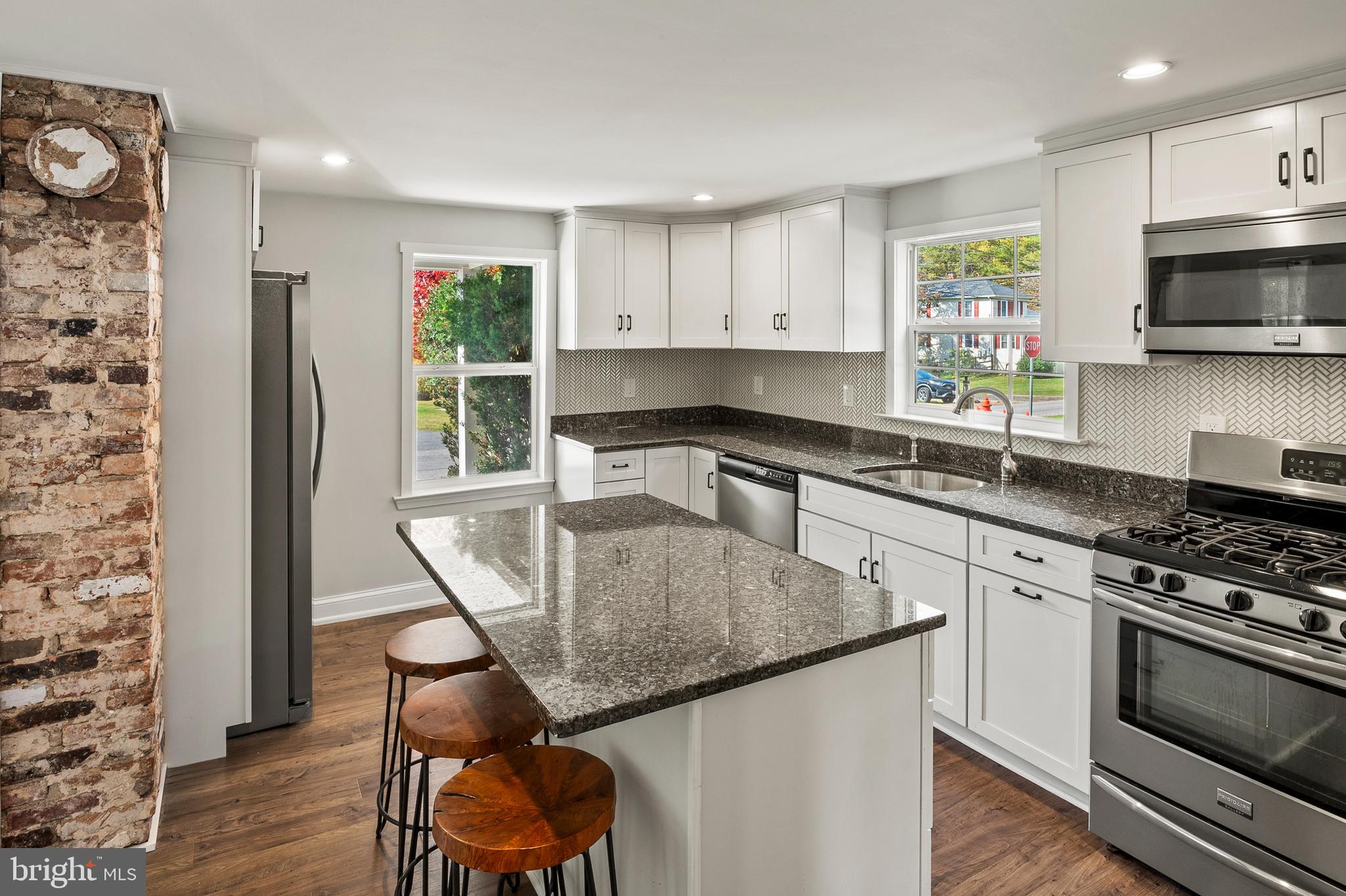 2201 Alvin Avenue Baltimore, MD 21228 - Photo 7 of 39 a kitchen with stainless steel appliances granite countertop a stove a sink a microwave a refrigerator and cabinets