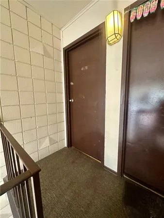 an empty room with wooden floor and a kitchen