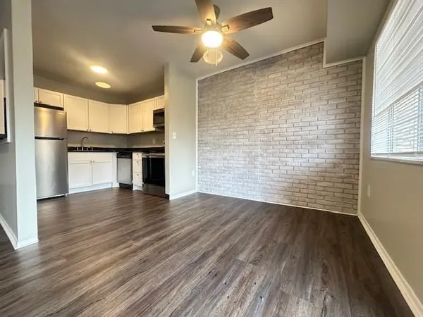 a kitchen with granite countertop wooden floors stainless steel appliances and sink