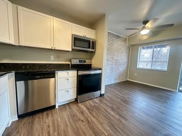 a kitchen with a refrigerator stove and wooden cabinets
