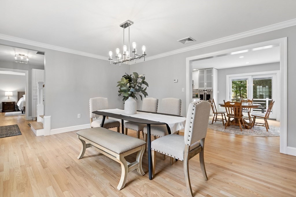 11 Fort Pond Road Acton, MA 01720 - Photo 15 of 40 a dining room with wooden floor a chandelier a wooden table and chairs