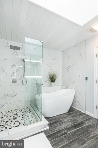 a bedroom with bed painting on the wall and a large window