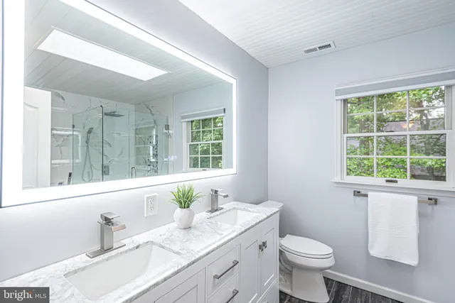 a bathroom with a sink a toilet and shower