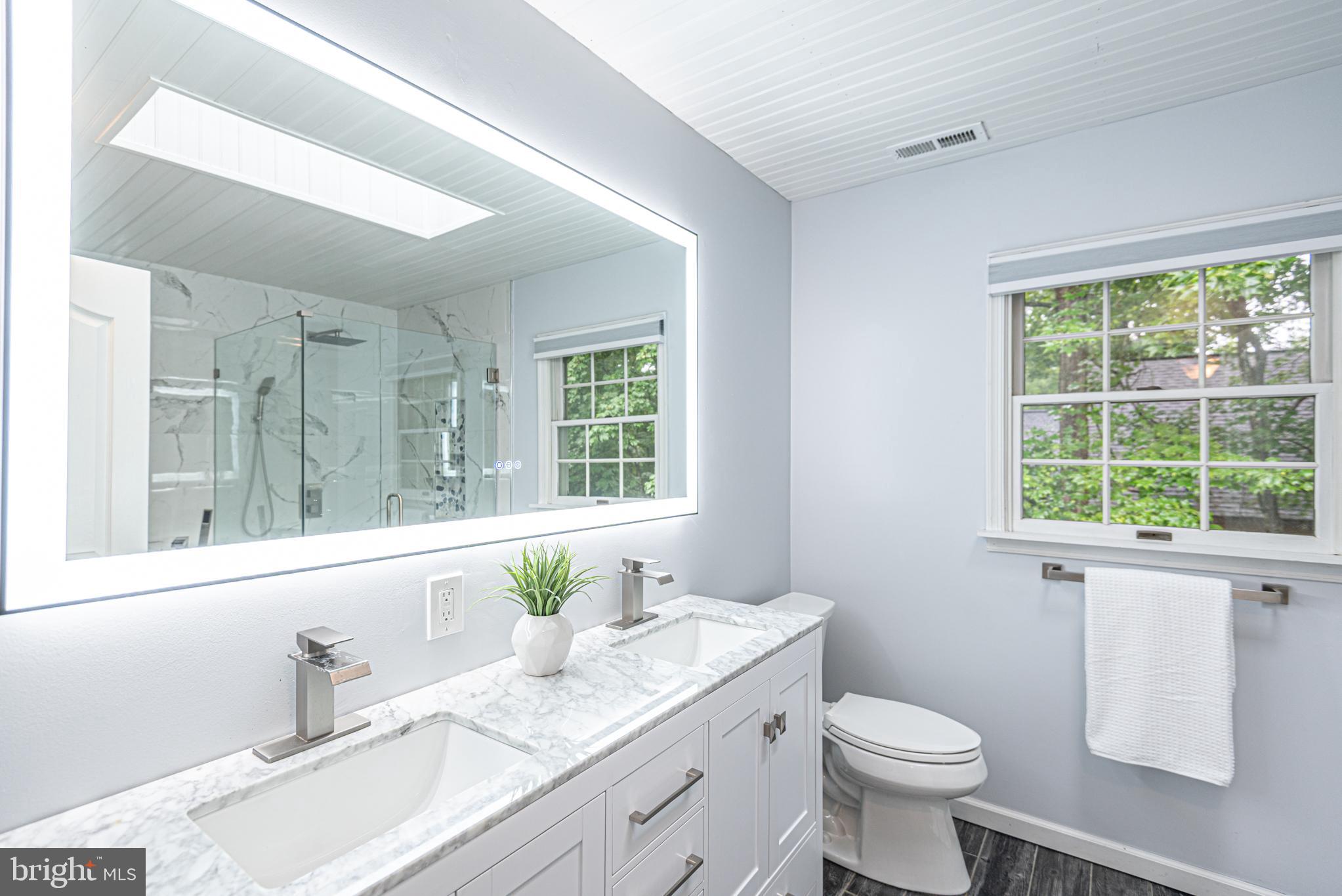 74 Birdnest Drive Ocean Pines, MD 21811 - Photo 25 of 89 a bathroom with a granite countertop toilet a sink a mirror a window and vanity