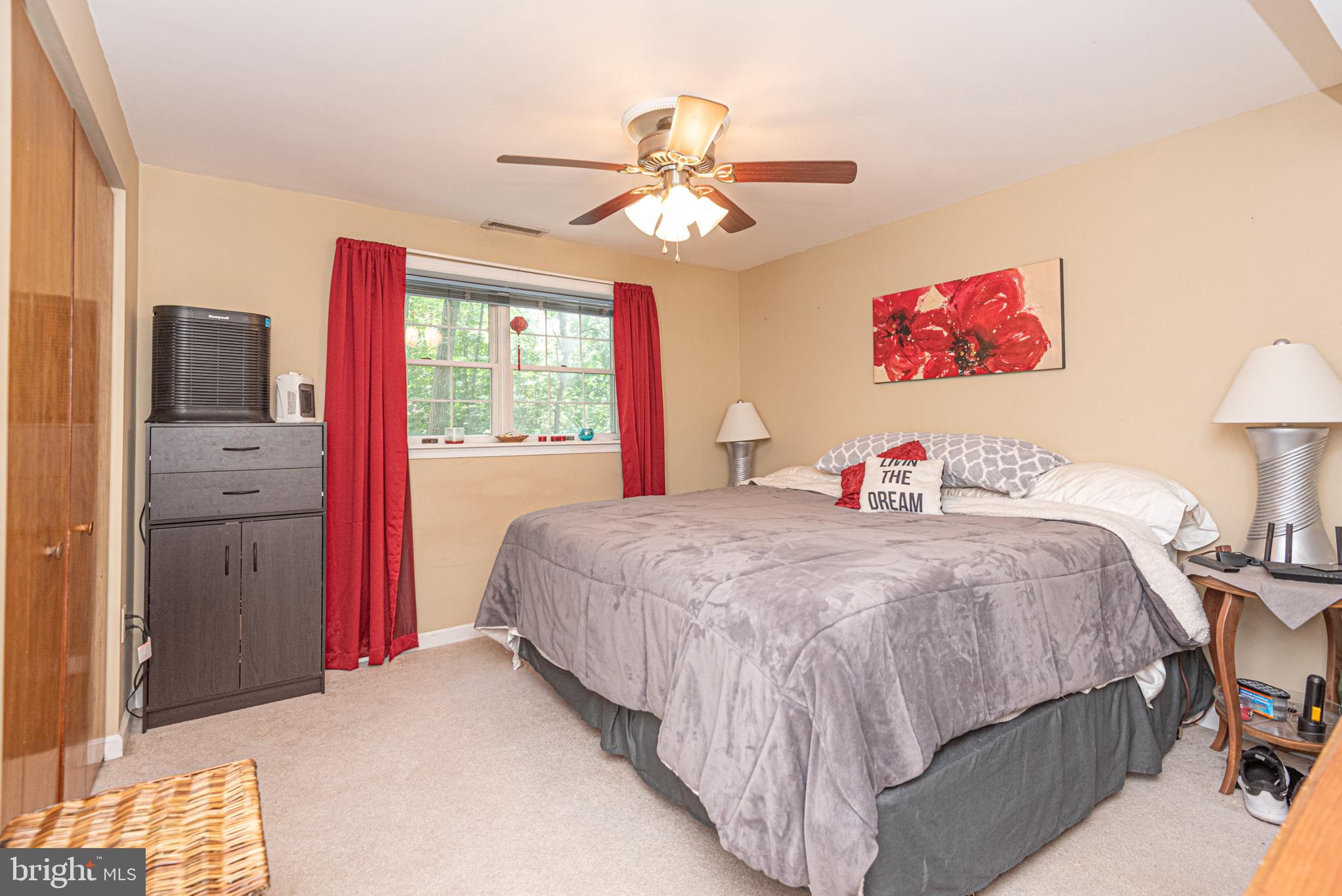 74 Birdnest Drive Ocean Pines, MD 21811 - Photo 62 of 89 a bedroom with a bed and a chandelier