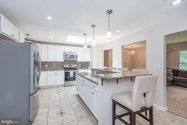 a kitchen with granite countertop a stove sink and cabinets