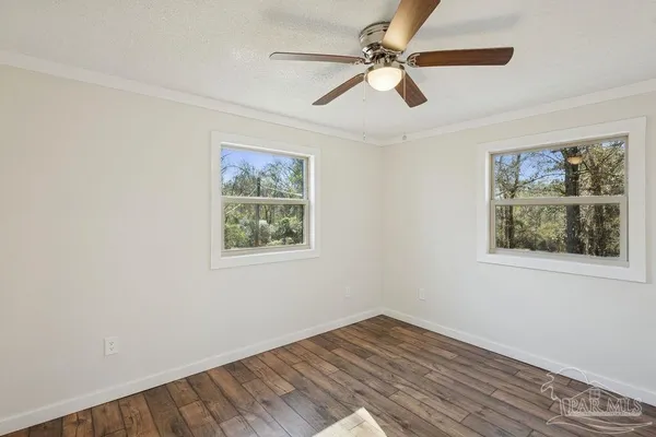 a view of empty room with wooden floor