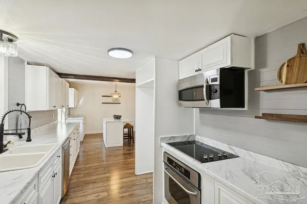 a kitchen with stainless steel appliances kitchen island a stove a sink and a refrigerator