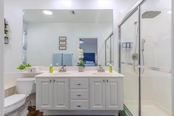 a bathroom with a double vanity sink mirror and toilet