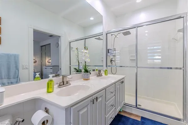 a bathroom with a granite countertop sink mirror and a bathtub