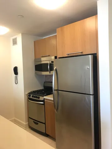 a kitchen with a refrigerator a stove and a microwave