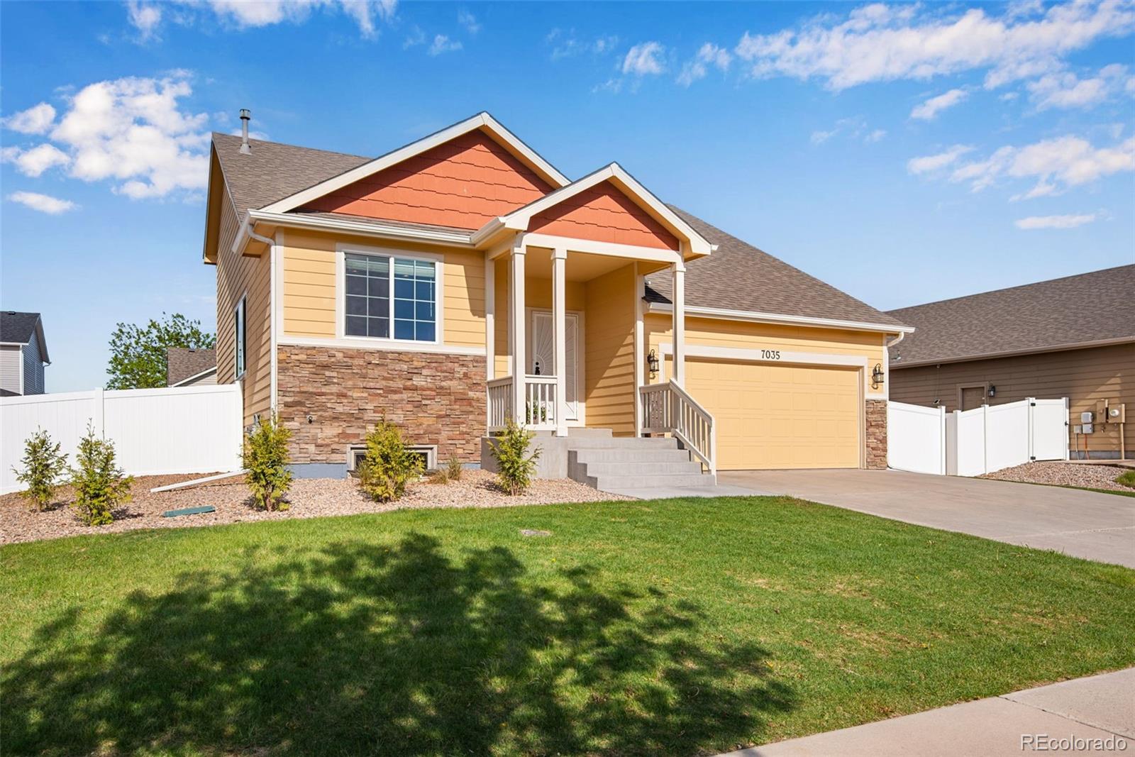 7035 McClellan Road Wellington, CO 80549 - Photo 20 of 43 a front view of a house with a yard and garage
