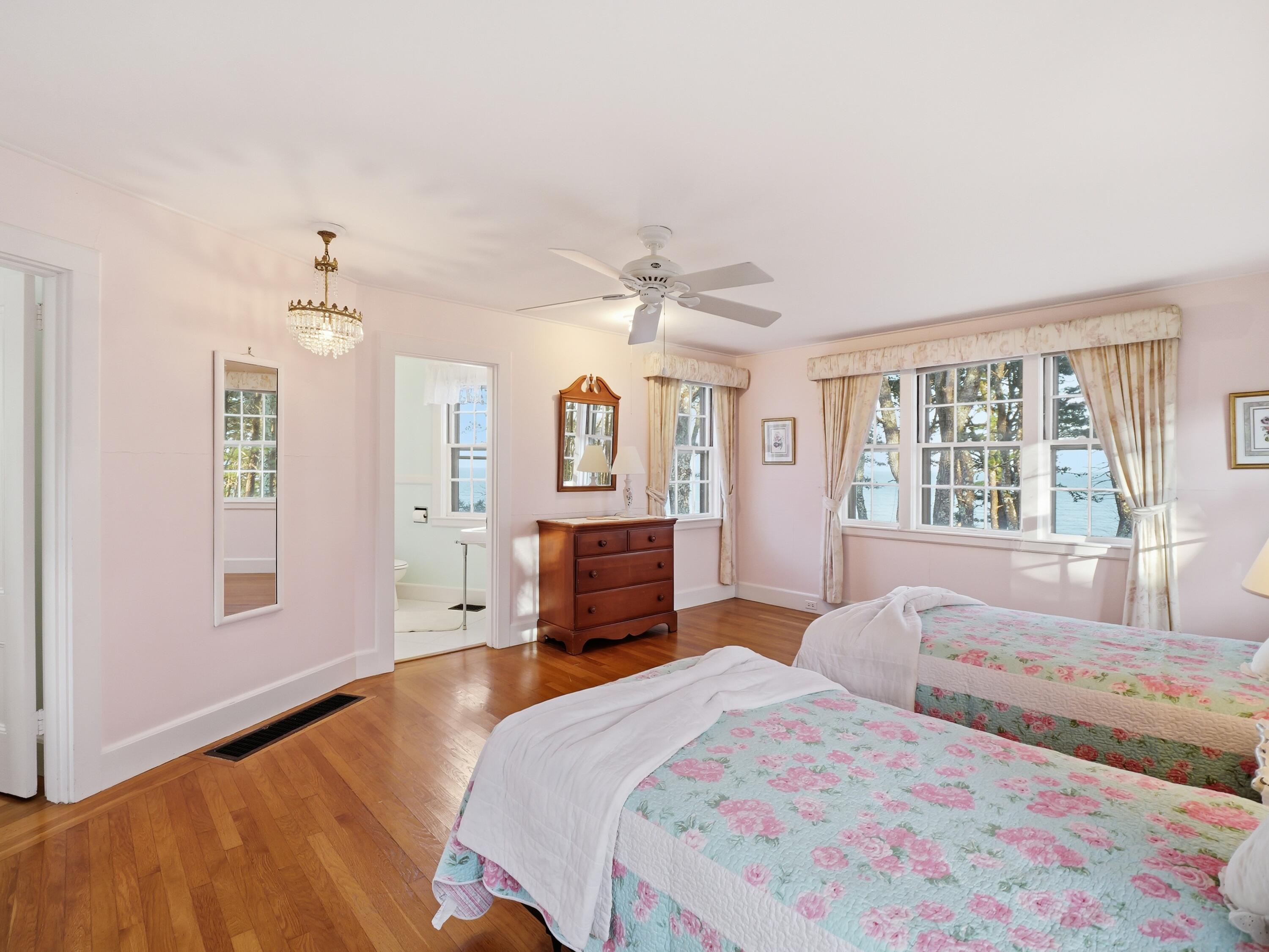 190 Vineyard Road Cotuit, MA 02635 - Photo 29 of 41 a spacious bedroom with a large bed a chandelier and windows
