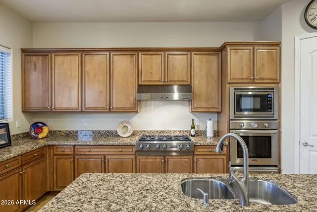 a kitchen with granite countertop a stove sink and cabinets