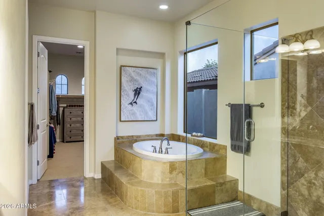 a bathroom with a tub a mirror and shower