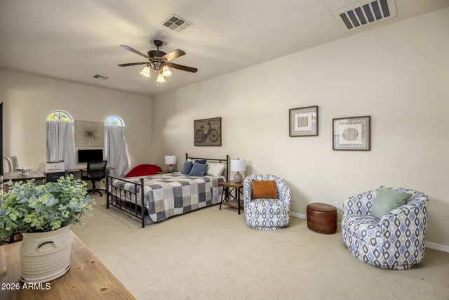 a spacious bedroom with a bed and a chandelier