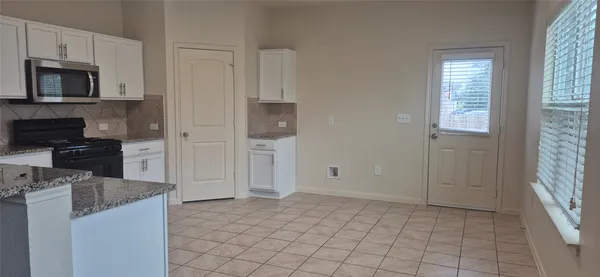 a kitchen with granite countertop a refrigerator and a stove top oven