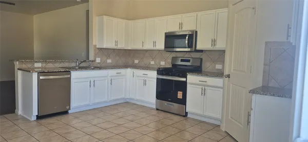 a kitchen with a sink stove and microwave