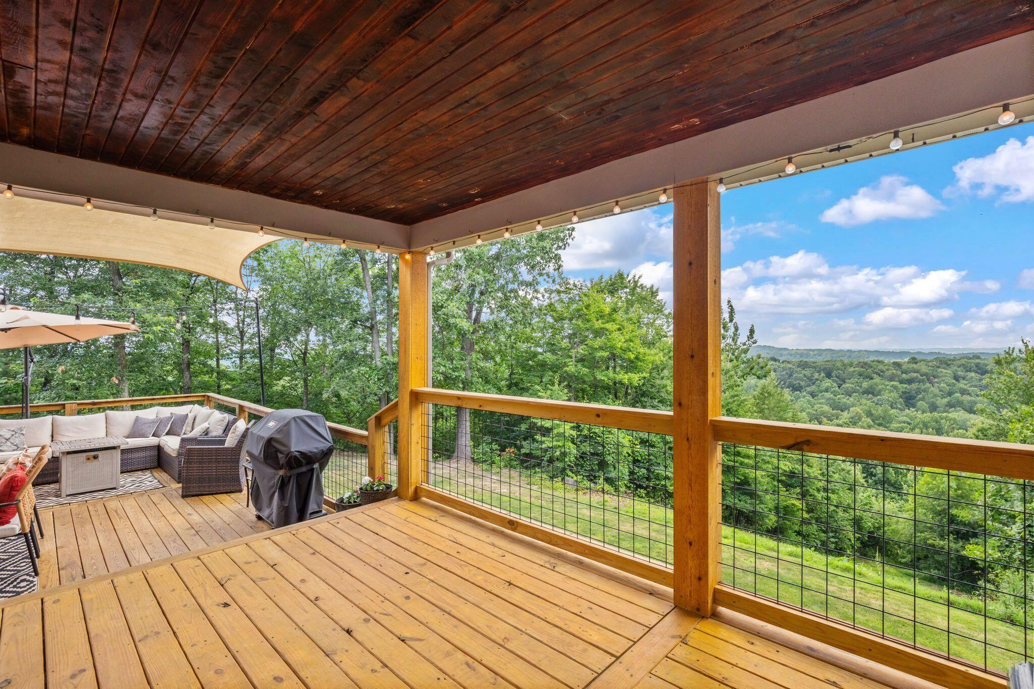 10446 Rich Hollow Road Southwest Lancaster, OH 43130 - Photo 82 of 83 Expansive elevated wood deck featuring a dark wood plank ceiling, string lighting, and a cable railing system