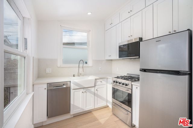 a kitchen with white cabinets and white appliances