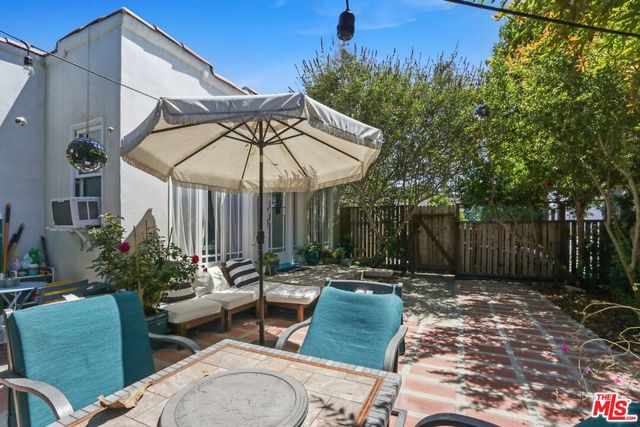 a patio with a table and chairs under an umbrella