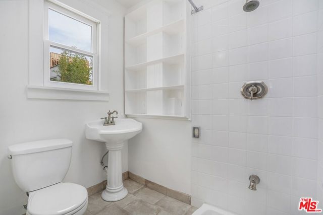 a bathroom with a sink a toilet and mirror
