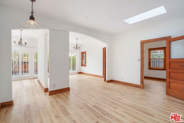 a view of a big room with wooden floor and windows