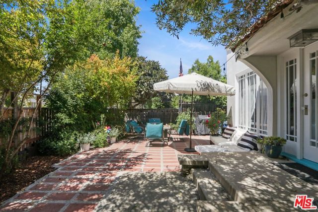 a view of a patio with chairs and a small yard