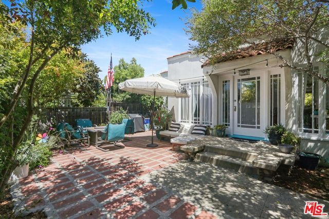 a view of a house with backyard sitting area and garden