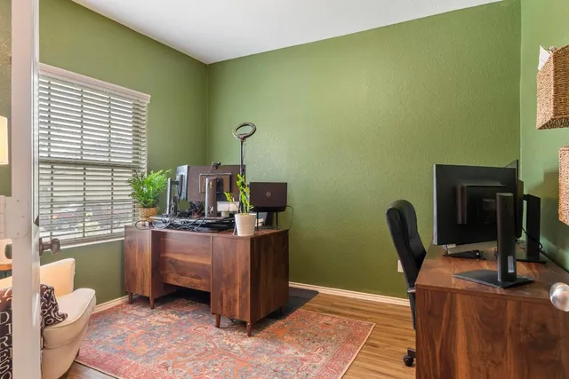 a view of a workspace with furniture and a window