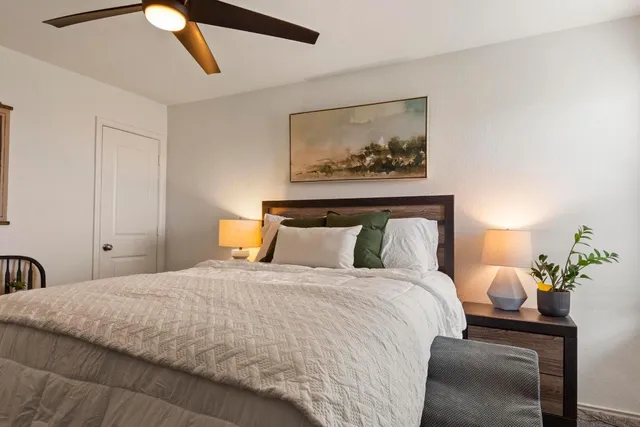 a bedroom with a bed and a painting on the wall