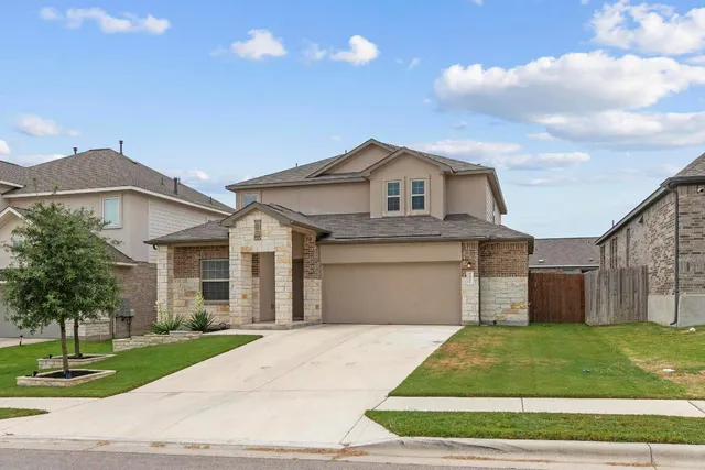 a view of a house with backyard and sitting area