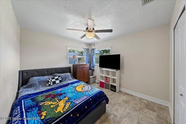 a bedroom with a bed and a flat tv screen on the dresser
